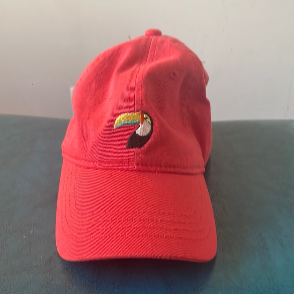 Peach hat with animal logo.